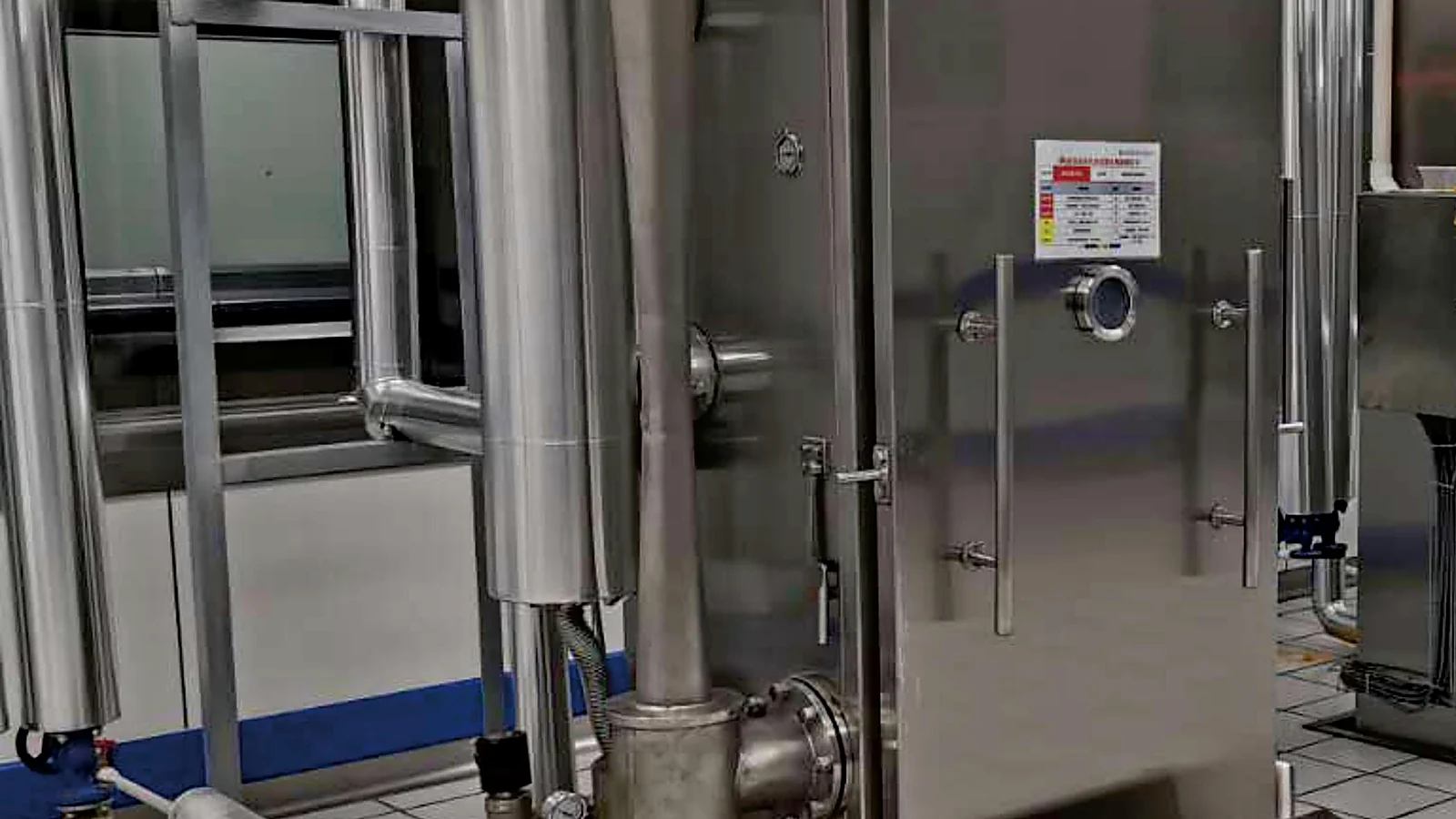 Close view of the stainless steel steam-ejector and condenser pipework on an Allcold food vacuum cooling system