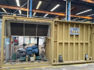 Allcold yellow vacuum cooler in the factory, with a finned heat exchanger above the refrigeration equipment frame