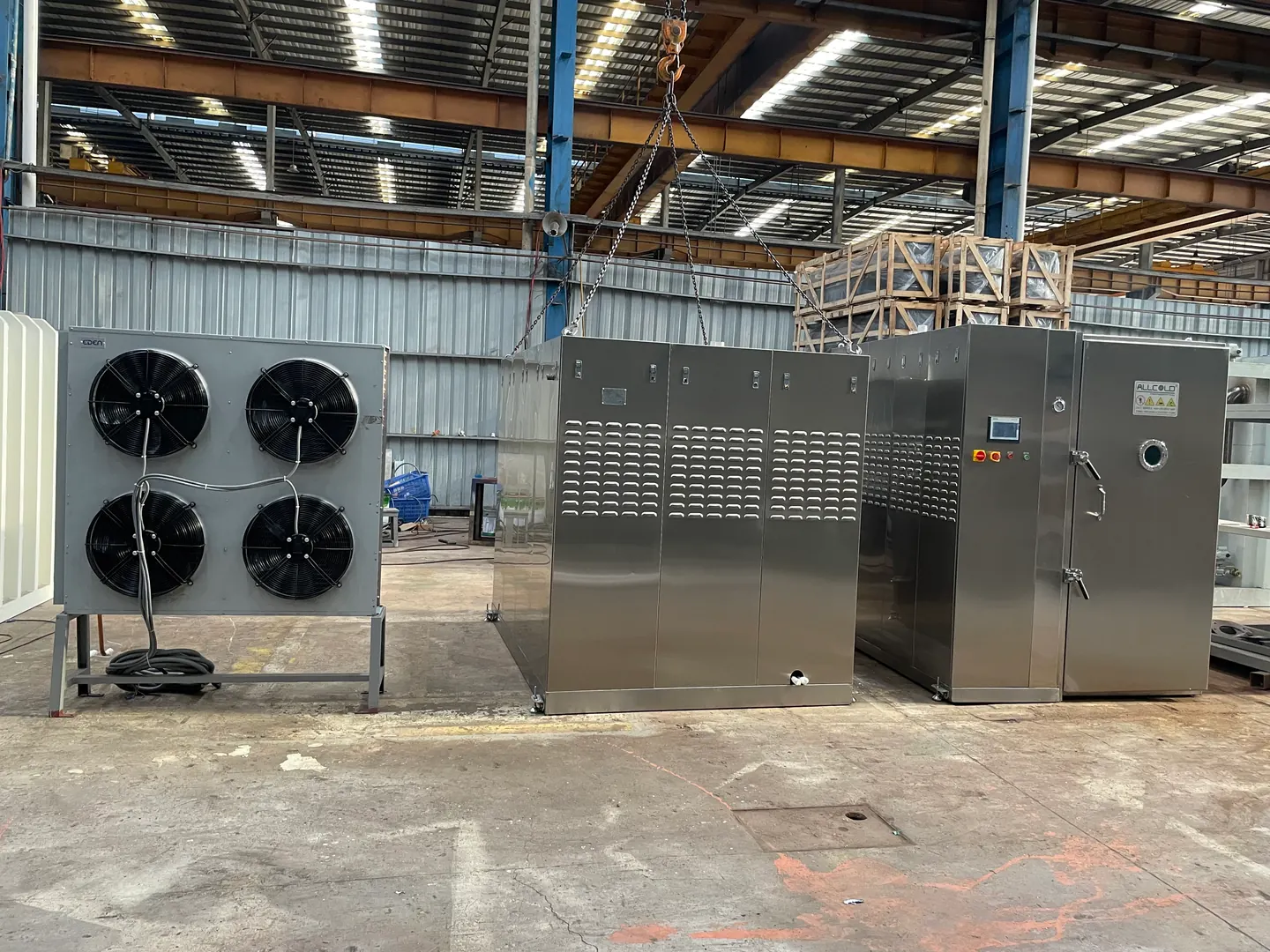 Allcold stainless equipment beside a separate four-fan heat-exchanger unit in the factory