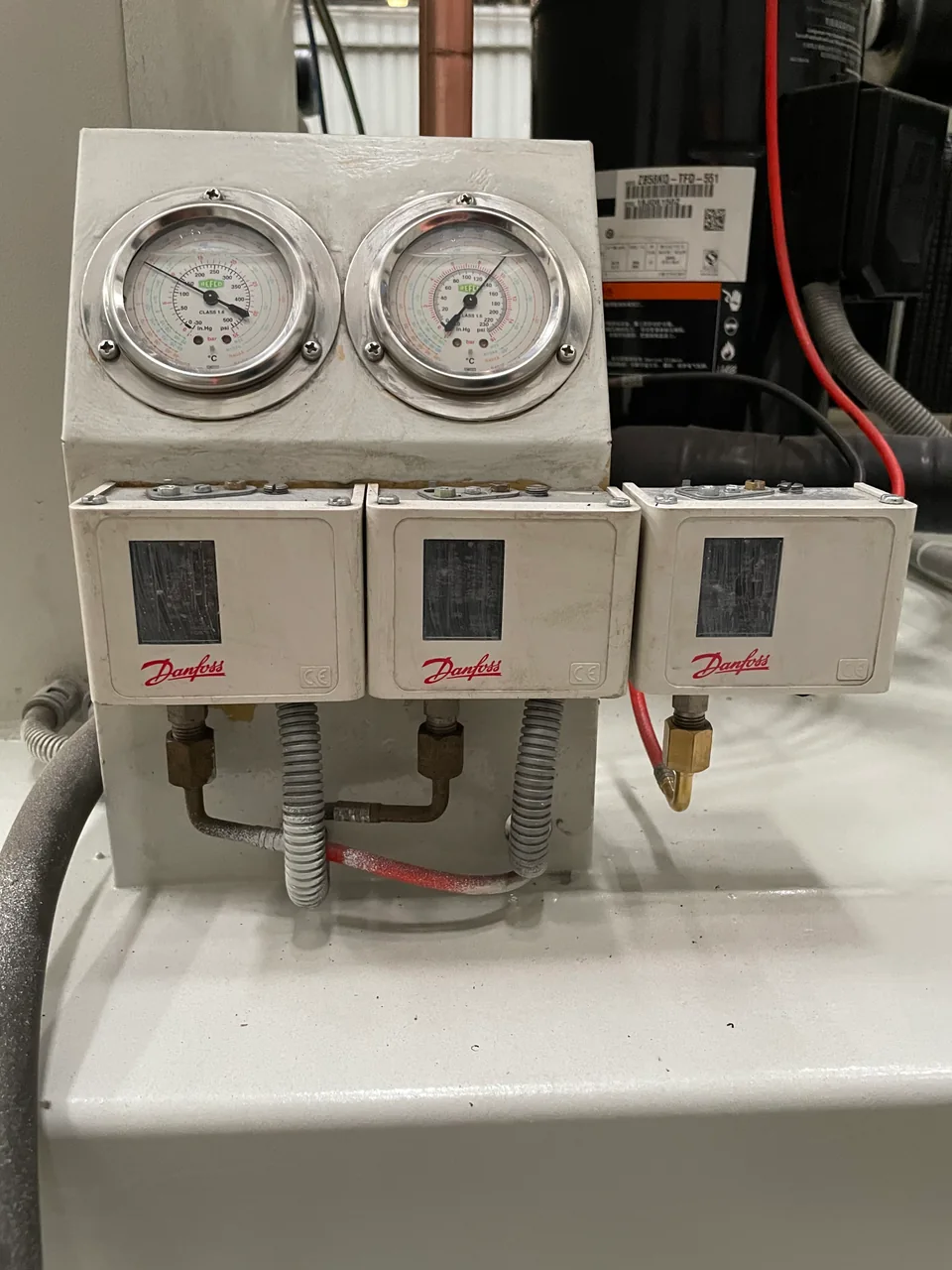 Close-up of high-side and low-side refrigeration pressure gauges and pressure switches on real Allcold equipment