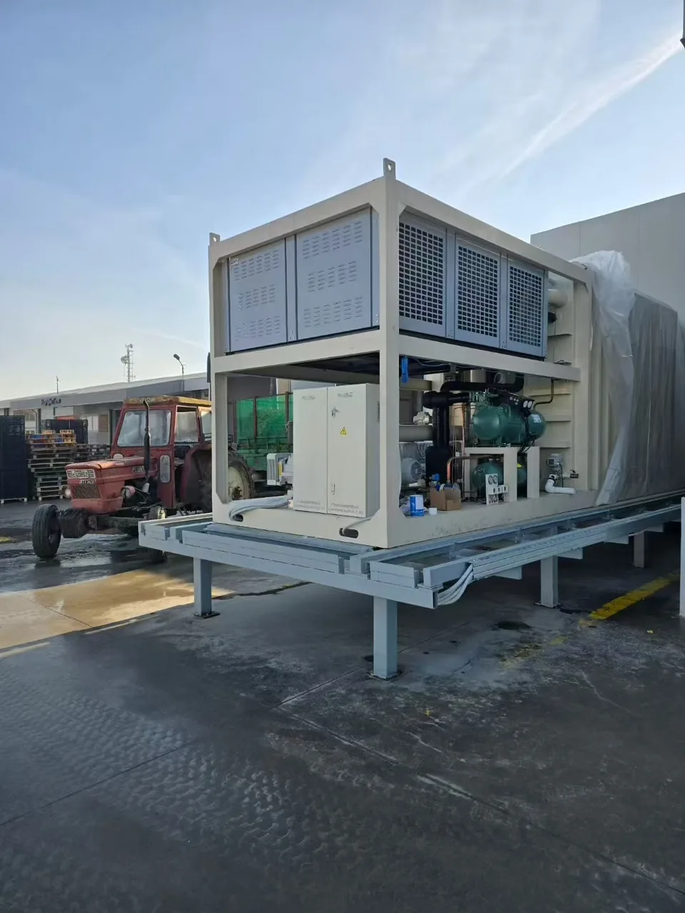 Real Allcold refrigeration assembly showing green compressors, pipework and the upper heat-rejection section