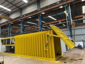 Yellow Allcold vegetable vacuum cooler in the factory, with its chamber door open and adjacent equipment frame visible