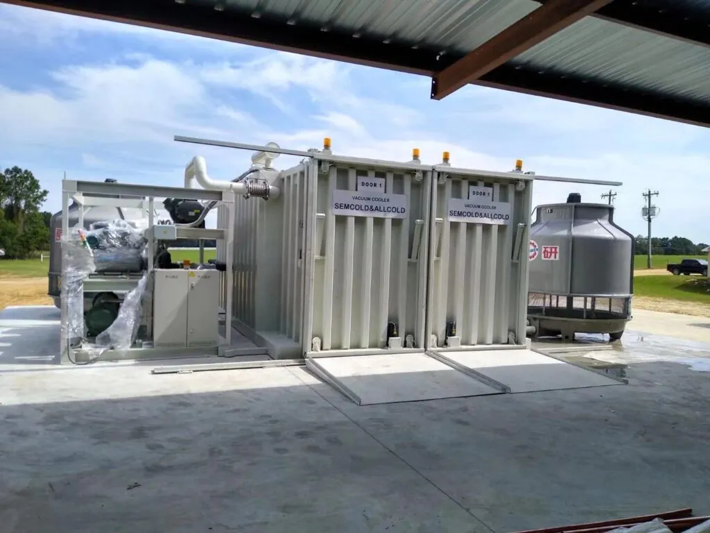 Dual-door vacuum cooling system installed outdoors with integrated condenser and control units, used for rapid cooling of fresh produce on farms