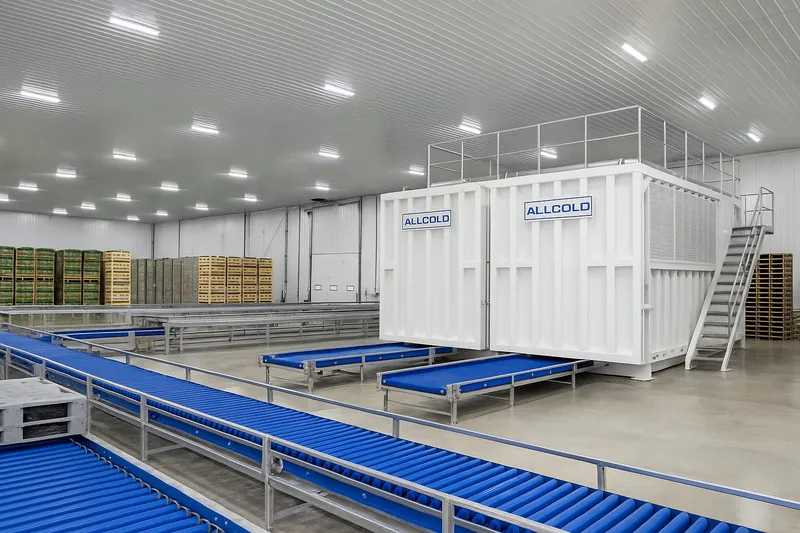 A wide shot of a massive, state-of-the-art packinghouse with an integrated 10-pallet vacuum cooler system and automated conveyor lines.