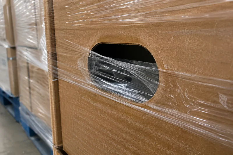 Close-up of a waxed carton vent opening showing partial blockage from stretch wrap overlap — illustrating how palletising can seal carton vents